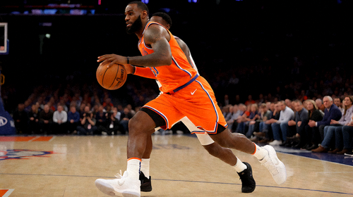 勒布朗詹姆斯在NBA比赛中运球突破防守球员准备上篮的动作瞬间